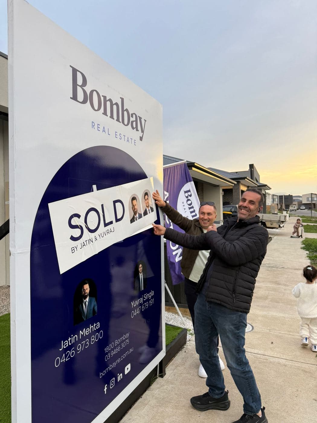 A Bombay Real Estate sold board going up at dusk