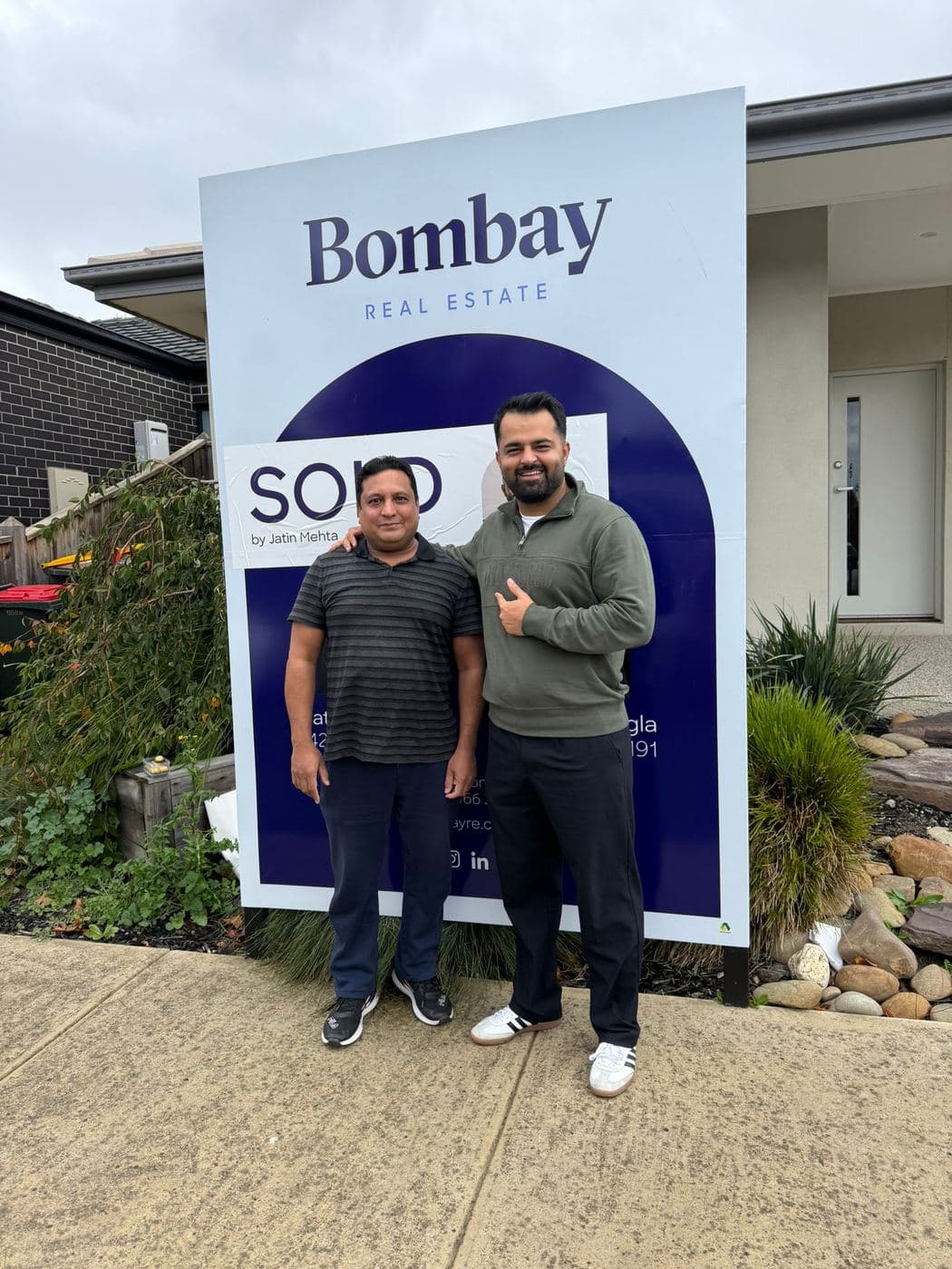 A buyer and agent at a sold board