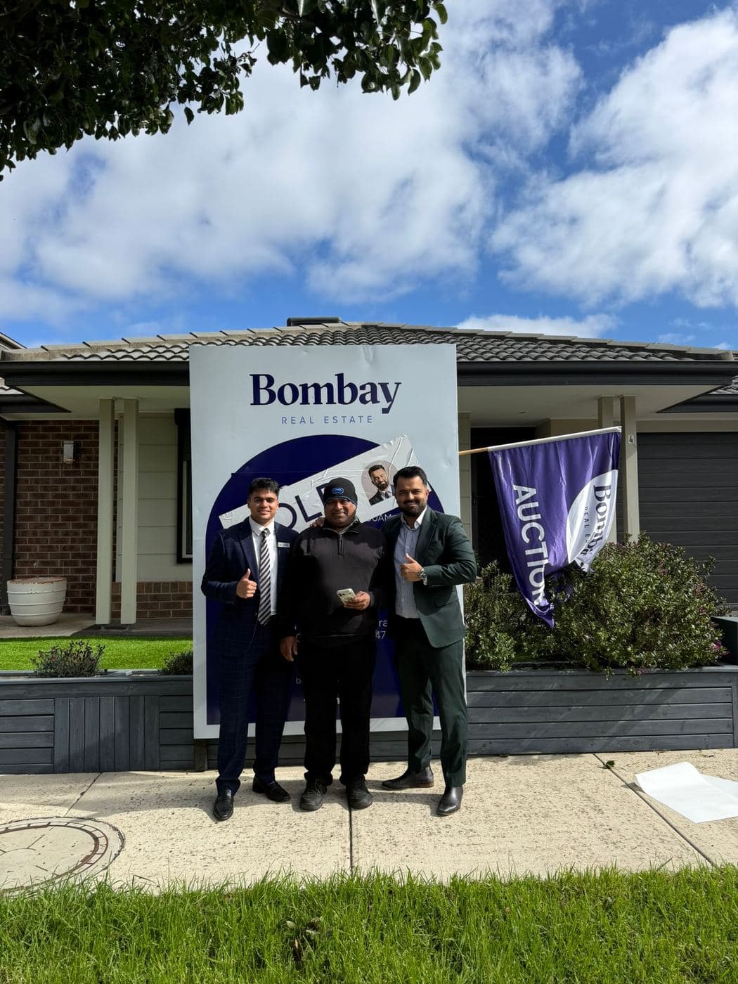 Buyers with the team at a sold board