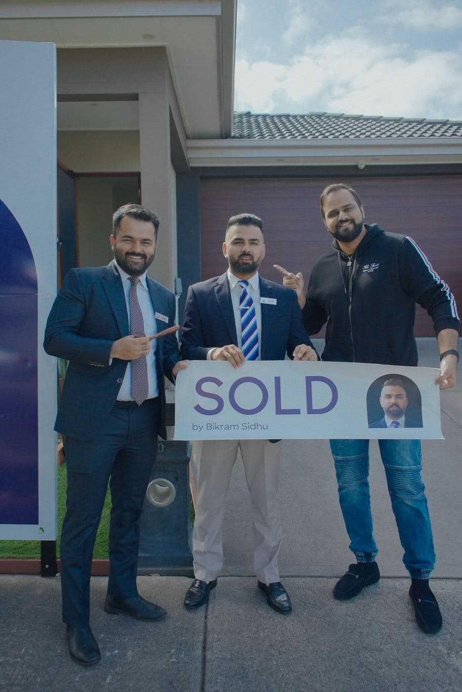 Jatin and colleagues with a seller beside a sold board