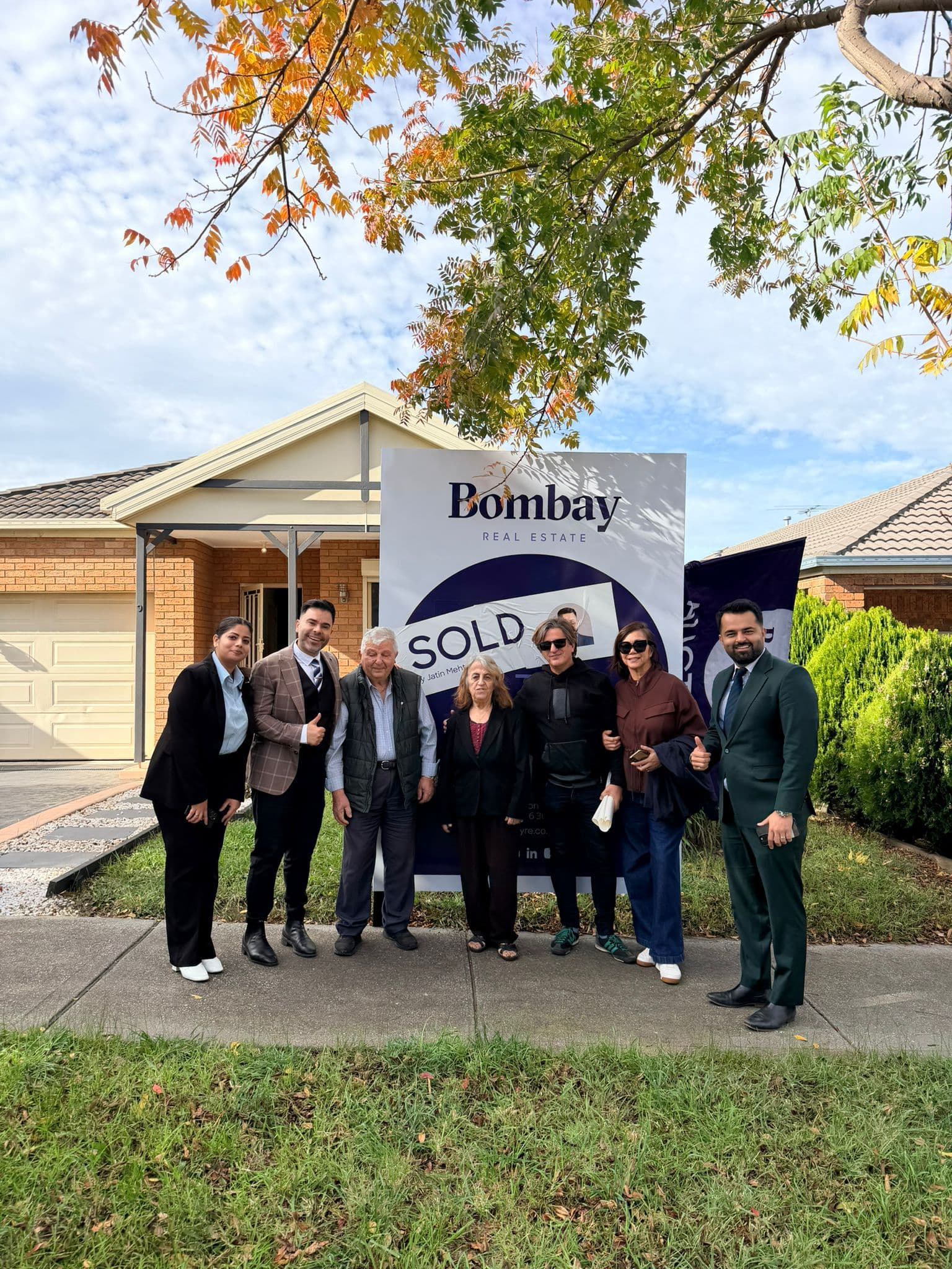 Vendors and the sales team gathered at a sold board